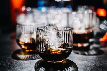 Whiskey Cocktail with Ice Sphere in a Moody Bar Setting