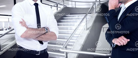 Composite image of smiling businessman with arms crossed