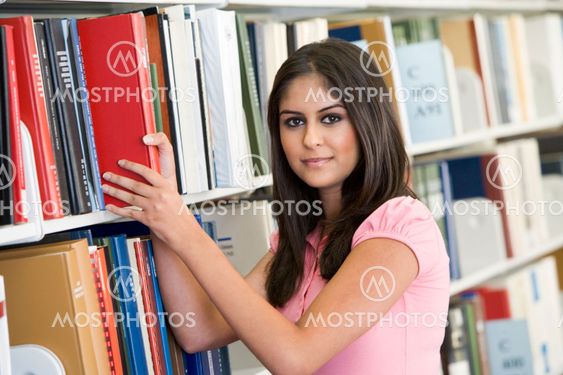 University student selecting book from library