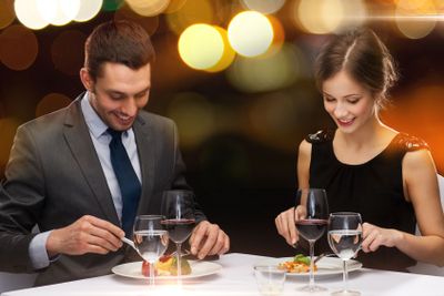 smiling couple eating main course at restaurant