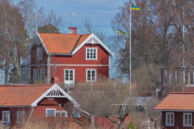 Red houses with a swedish flag at trip to Rodloga, one of...