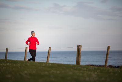Young woman on her evening jog along the seacoast