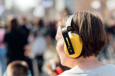 Female protester wearing earmuffs on the street during...