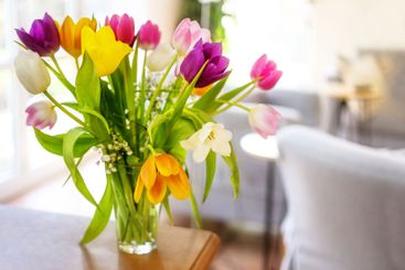 Colorful bouquet of tulip flowers on a wooden table in...