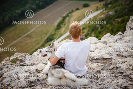 hiker with siberian husky dog looking at beautiful view...