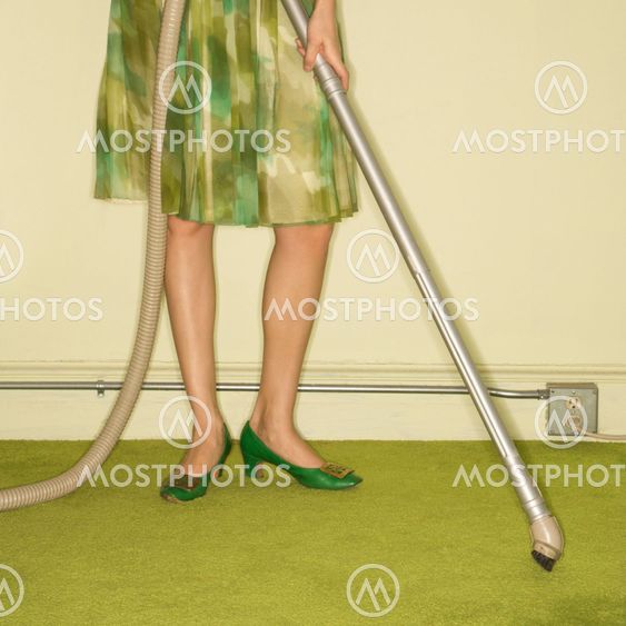 Woman vacuuming rug.