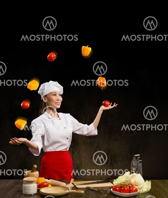 Asian woman chef juggling with vegetables