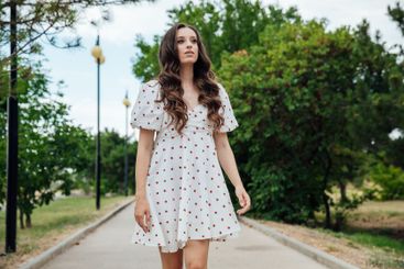 slim fashionable brunette woman in summer white dress...