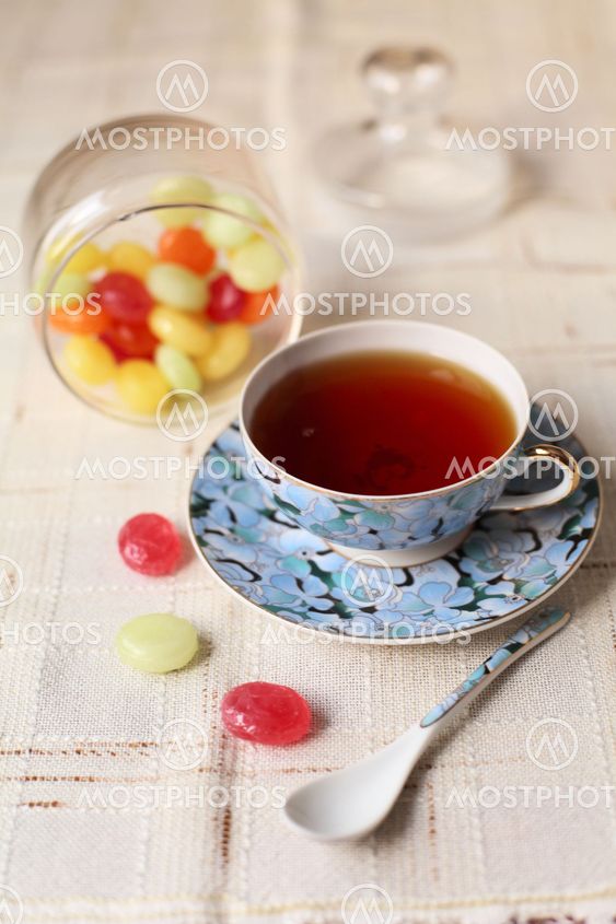 Tea with coloured sugar candies in a glass can