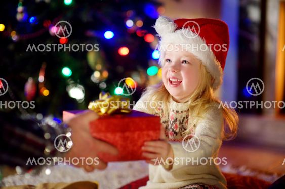Happy little girl getting a Christmas gift from her parent