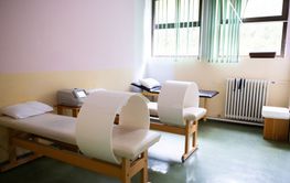 A well-lit physiotherapy treatment room featuring...