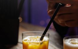 Whiskey sour cocktail on a wooden bar counter in a pub.