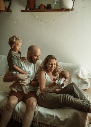 Parents, kids and a happy family on the sofa in the...
