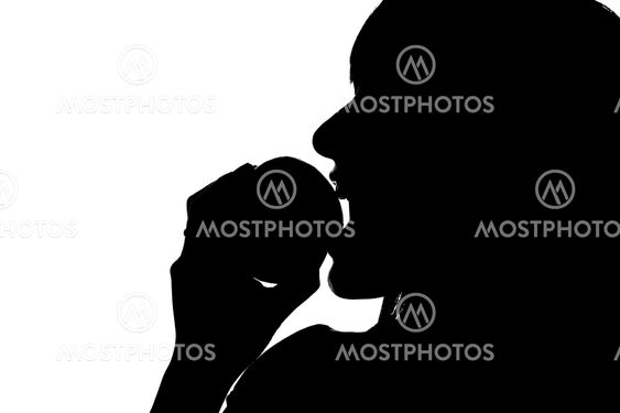 Silhouette of woman biting into apple