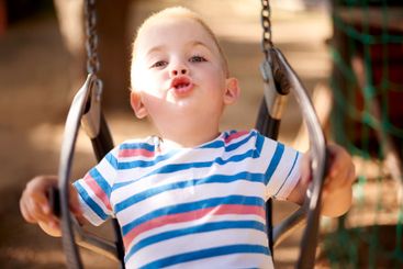 Fun, swing and portrait of kid in park with play,...