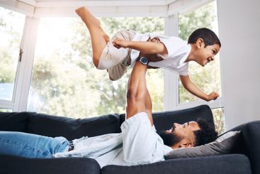 Dad, kid and support flying in home, parent lifting and...