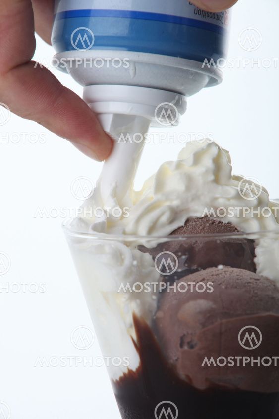 Squirting cream on chocolate ice-cream