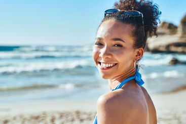 Beach, ocean and portrait of woman in summer in bikini...