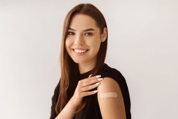 Young Caucasian woman showing shoulder with band aid...
