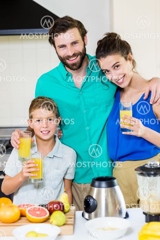 Family holding juice in kitchen