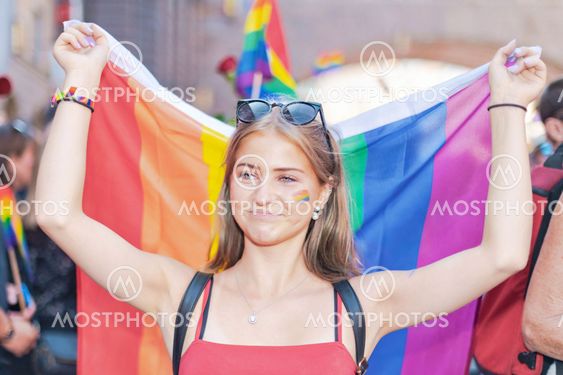 Girl carrying the pride flag at the pride parade