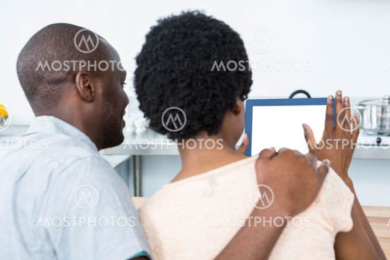 Pregnant couple looking at digital tablet