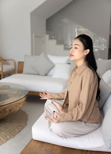 Serious peaceful young Asian yogi woman sitting in...