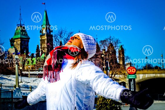 Young woman basks in the warm winter sun in front of...