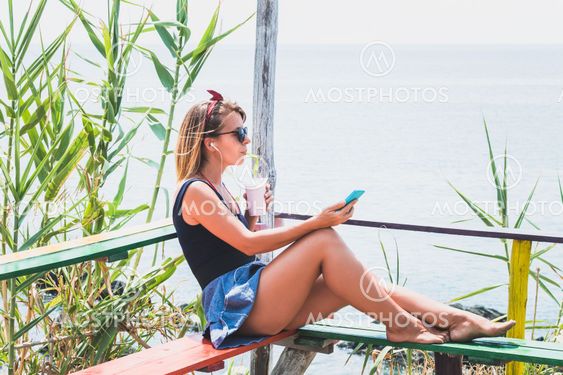 Young woman enjoying cold drink in a beach bar