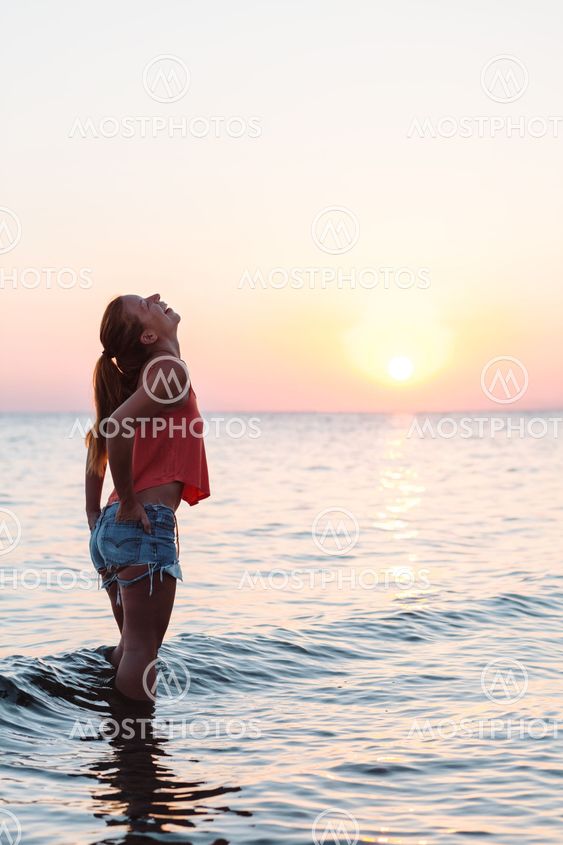 Young woman enjoying sea and sunset