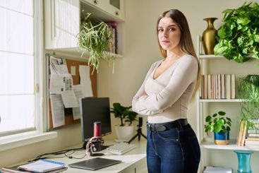 Portrait of young confident smiling woman in home interior