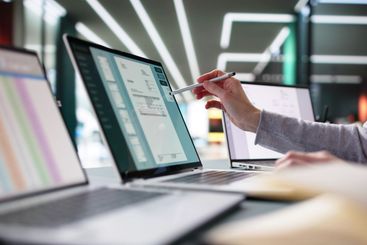 Young female accountant managing e-invoices on laptop