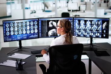 Doctors In Clinic Looking At Brain MRI Scan