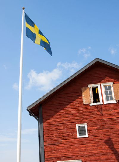 Old Swedish wooden house with flagpole