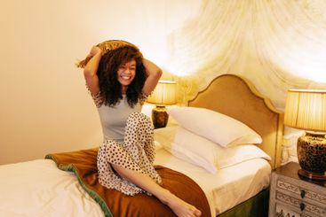 A charming African in casual clothes throws pillows in...