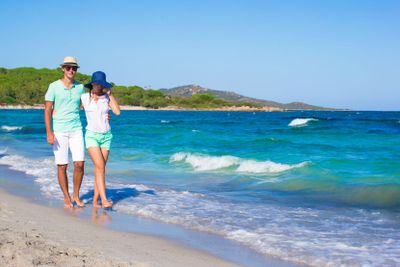 Happy family at white beach during tropical vacation