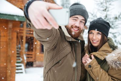 Couple standing and making selfie in snowy weather 