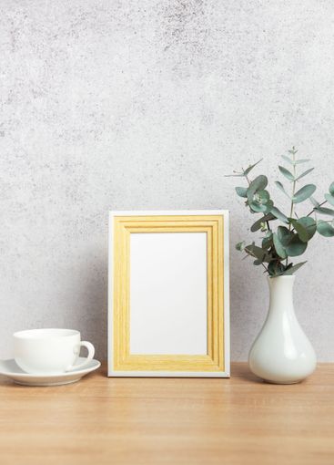 Empty photo frame, coffee cup and eucalyptus branches on...