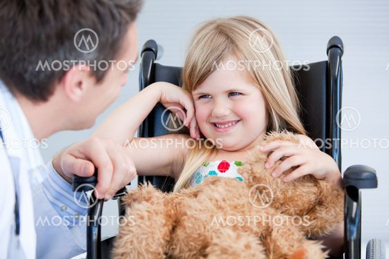 Laughing little girl sitting on the wheelchair