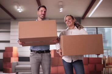 Happy Young Couple Moving Boxes