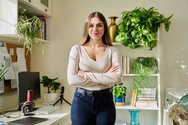 Portrait of young confident smiling woman in home interior