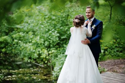 Attractive wedding couple standing and posing on a small...