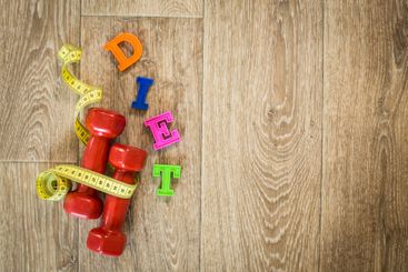 Fitness concept with dumbbells and measuring tape