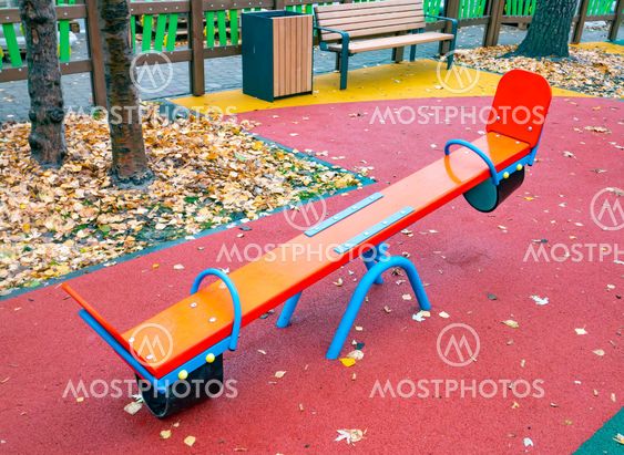 Children's playground with a swing in the autumn park.