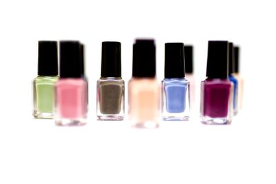 Coloured nail polish bottles on a white background