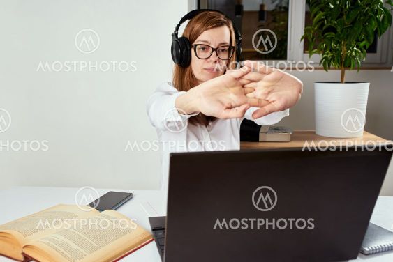Woman in the headphones streching arms after long...