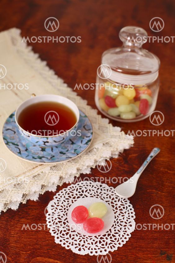 Tea with coloured sugar candies in a glass can