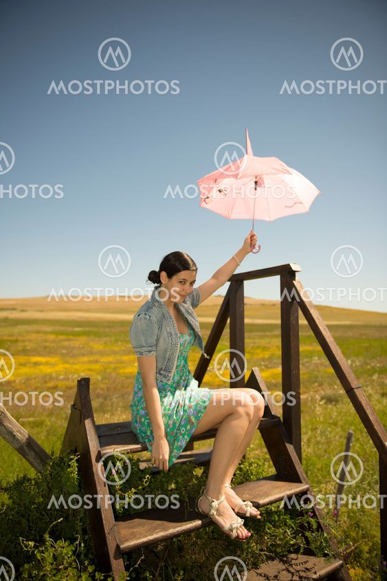 Beautiful adult smelling flowers on sunny field enjoying herself