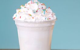 Extreme milkshakein plastic cup blue background