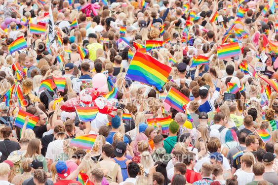 Pride parade in Stockholm with happy people and waving...